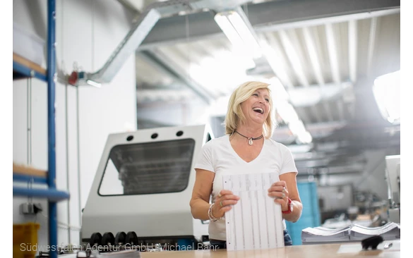 Mitarbeiterin an einem Druckerei-Arbeitsplatz